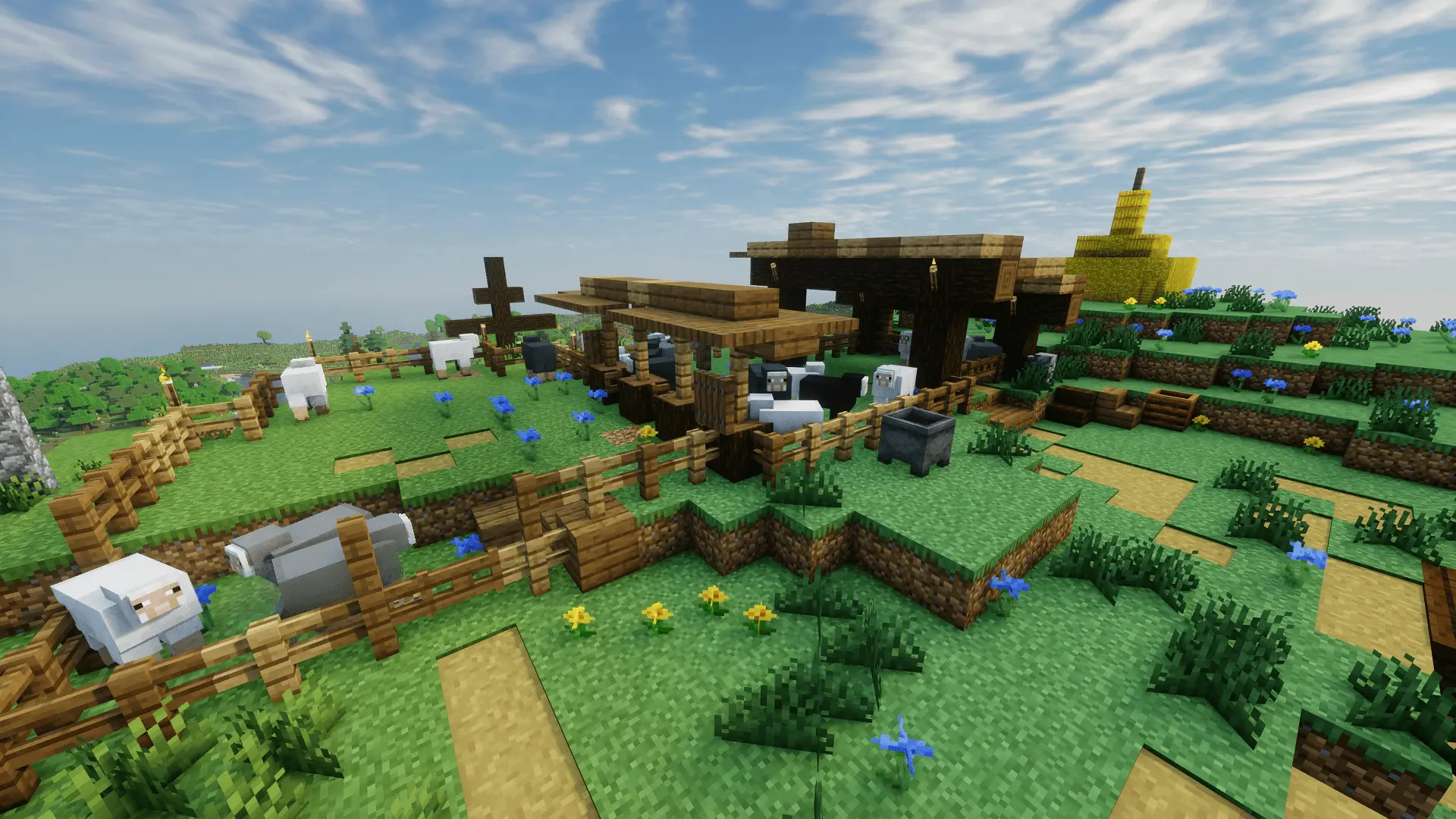 Sheep roam inside the enclosement, and nearby one can see hay bales and a big wooden cross serving as a place of worship and a guard against evil